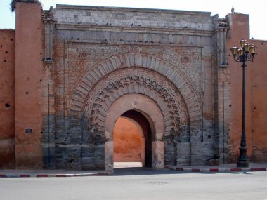 Marakeş, Fas 'ta süslü bir taş kapı olan Bab Agnaou' nun manzarasında İslami mimari ayrıntılar ve geleneksel arabesk oymaları yer alıyor..