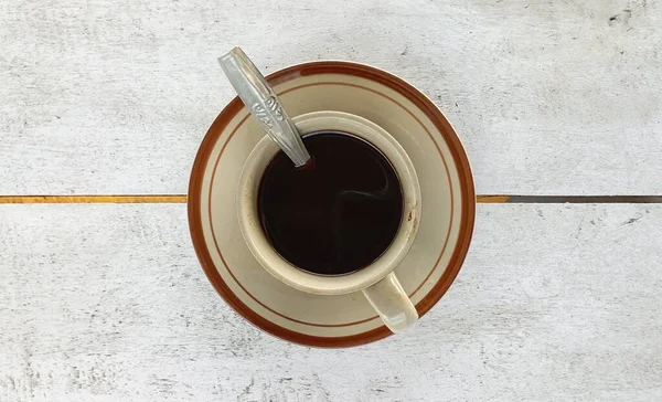 白い木製のテーブルの上に白いカップと白いソーサーで提供されるブラックコーヒー ショットアップ付きの写真ブラックコーヒー — ストック写真