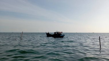 Mavi denizin ortasında bir gemi ya da tekne ve bulutlu beyaz bir gökyüzü.