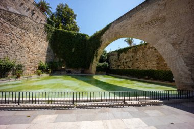 Güneşli bir günde bir kale avlusunda taş kemer.