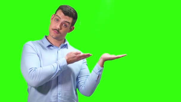 口ひげと青いシャツを着た面白い男が宣伝用の緑の画面のように彼の手に示しています 高品質4K映像 — ストック動画