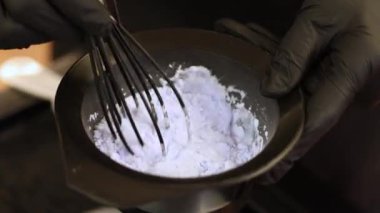 Siyah eldivenli kadın elleri kuru saç boyasını karıştırıyor. Yüksek kalite 4k görüntü