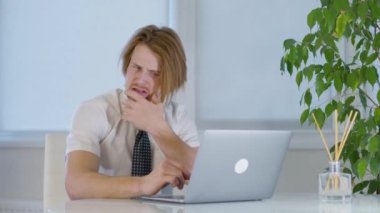 Ofisteki kızıl saçlı genç erkek işçi. Laptopta sinir bozucu. Şok hali. Yüksek kalite 4k görüntü