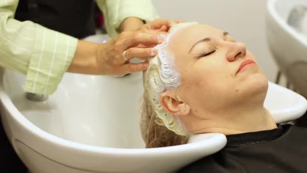 美容室で年を取った金髪の女の頭を洗う 美容室の手 高品質4K映像 — ストック動画