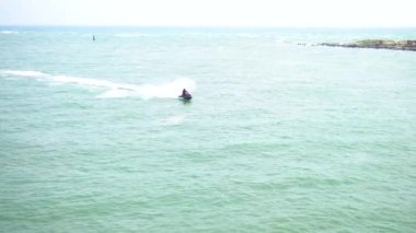 Güneşli bir günde mavi denizde jet ski süren bir adam. Yüksek kalite 4k görüntü