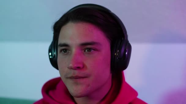 Retrato Hombre Joven Con Auriculares Jugando Videojuego Una Habitación Colorida — Vídeos de Stock