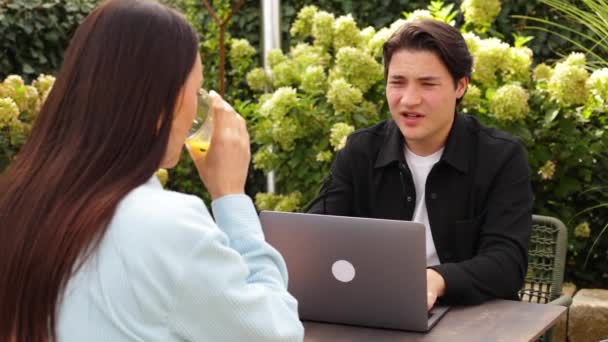年轻男子与女友进行认真友好的交谈时 坐在咖啡桌旁 男性女性朋友 高质量的4K镜头 — 图库视频影像