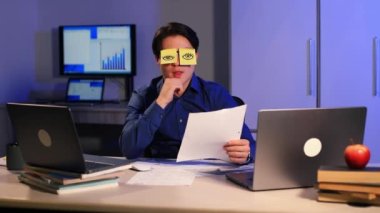 Uykulu tembel ofis çalışanı işadamı masasına oturur komik komik çıkartmalar yapıştırmalar yapıştırır yorgun yorgun çalışanın uykusu dinlenirken uyur. Yüksek kalite 4k