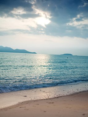 Kumsalda kum ve mavi yaz gökyüzü. Sahil manzarası. Boş tropik plaj ve deniz manzarası. Günbatımı gökyüzü, yumuşak kum, sakinlik, dinlendirici güneş ışığı, yaz havası. TEXT İçin Boşluk