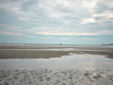 Kumsalda kum ve mavi yaz gökyüzü. Sahil manzarası. Boş tropik plaj ve deniz manzarası. Günbatımı gökyüzü, yumuşak kum, sakinlik, dinlendirici güneş ışığı, yaz havası. TEXT İçin Boşluk