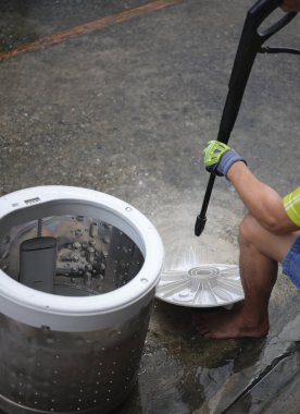 Tamircinin elleri varili temizlemek, elektrikli ev aletlerinin tamiri veya temizlik hizmetleri konsepti için su püskürtme makinesini kullandıktan ya da çıkardıktan sonra