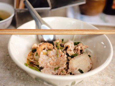 Tayland sokak yemeği. Erişte Tom Yum, domuz etli ve baharatlı erişte, Kapalı Baharatlı Tom YAM, Baharatlı limon otu aromalı domuz aromalı şehriye.. 