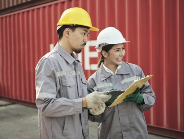 Mühendisler problemleri tartışıyor ve bir not alıyor. Müdür, kargo konteynır alanının etrafını saran işle ilgili düşüncelerini paylaşıyor.