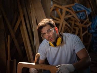 Profesyonel marangoz ahşap atölyesindeki ahşap mobilyaları profesyonel yüksek beceri yapan mobilyalar gibi göstermeye çalışmaktan mutlu. başyapıtlar . 