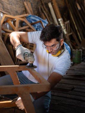 Profesyonel marangoz ahşap atölyesindeki ahşap mobilyaları profesyonel yüksek beceri yapan mobilyalar gibi göstermeye çalışmaktan mutlu. başyapıtlar . 