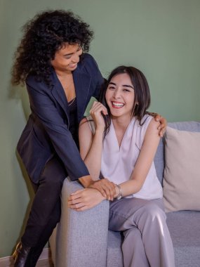 Modern bir kanepede rahat bir şekilde oturan şık Igbtq genç kadın, çağdaş bir evde keyif ve rahatlama hissi yayıyor..