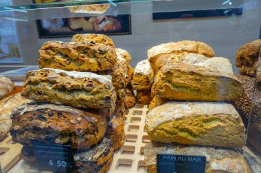 French bread in the glass vitrine of a bakery in a shopping centre in France, with price labels indicating the presence of gluten and allergens