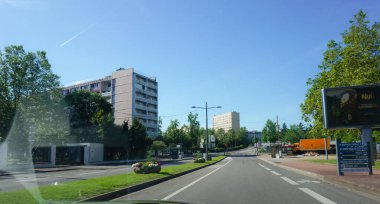 Bron, Fransa - Haziran 2019 - Fransa 'nın en büyük ikinci şehri olan Lyon kentinin popüler bir mahallesinde binaların (sosyal konutların) bulunduğu bisiklet yolu ile çevrili yapraklı bir cadde