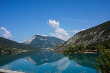 Grandiose mountain landscape in French Southern Alps : the turquoise-water of the Lake of Castillon, bordered by rocky cliffs and mountains, in the Gorges of Verdon, in Haute-Provence, France clipart