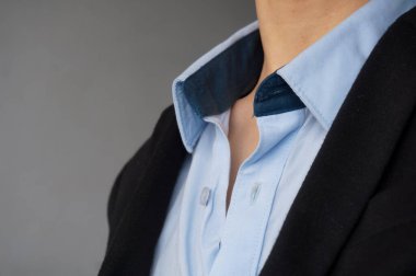 Siyah bir takım elbise ve rahat bir şekilde giyilen mavi bir gömleğin tasması.