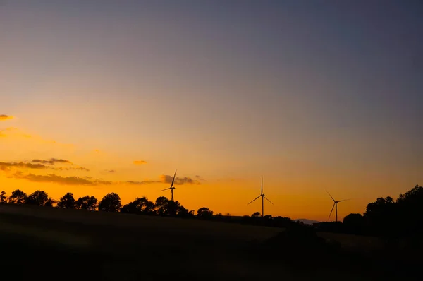 Rüzgâr Türbinleri Bir Rüzgar Çiftliğinin Ufkunda Hizalanmıştı Önünde Tarlalar Günbatımı — Stok fotoğraf