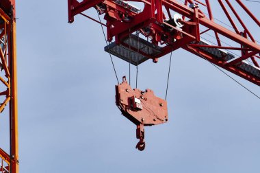 Bir inşaat alanındaki vinç ayrıntıları, yükü kaldırmak için çelik kanca ve ana patlamada raylara monte edilmiş olan mobil vagona bağlı makara sistemi.