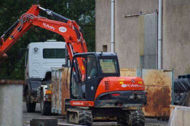Tarn, Fransa - Aralık 2020 - Japon inşaat ekipmanı üreticisi Kubota 'nın kırmızı, kompakt pistli mini kazıcısının fabrika dışında bir kamyonun arkasında çalışırken görüntüsü