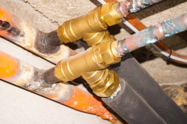 Şehir gazına bağlı merkezi bir ısıtma sisteminin propan tedariği için polistiren ambalaj ve kaynak izleriyle birlikte bakır ve pirinç boruların ayrıntıları,