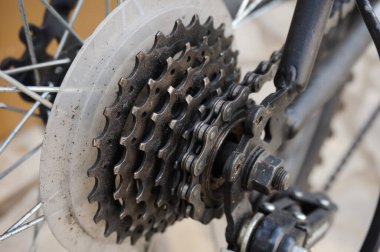 Dağ bisikletinin 6 vitesli şanzımanının ayrıntıları ve arka tekerleğin eksenine monte edilmiş pinyonların daha yakın görüntüsü, zincir arka rayların son dişlisine yerleştirilmiş.