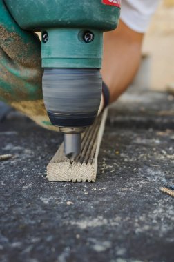 Yüzeyde bir oyuk oluşturmak için, büyük çaplı bir yuvarlak, elektrikli matkap mandrel ile entegre, taş bir masa üzerine küçük ahşap tahta üzerine uygulanır