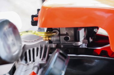 Alman yapımı yepyeni bir benzin fırçası kesicisinin makine parçaları: termal motor karbüratörünün plastik karbüratöründeki yağ ve gaz kabarcıklarıyla metal karbüratöre bağlı giriş hortumlarının ayrıntıları