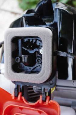 Yepyeni bir Alman yapımı benzin fırçası kesicisinin çelik mekanik bileşenleri: termal motorun karbüratöründeki hava girişinin kontrolü için köpük filtresi, başlatıcı ve boğma kolu ayrıntıları