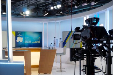 Reims, Fransa - Haziran 2022 - Yerel haber kanalı Fransa 3 Champagne-Ardenne 'in stüdyo seti içinde televizyon kameraları, mikrofonlar, modern mobilyalar ve mavi renkli ahşap masa