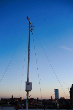 Meteoroloji istasyonunun kablolarıyla sabitlenen çelik çubuk, hava ölçümleri ve hava kirliliği kontrolü için algılayıcıları içeren Carmes otoparkının tepesine şafak vakti mavi bir gökyüzü arka planında yerleştirildi.