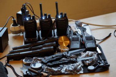 Occitanie, Fransa - Aralık 2021 - Bazı hayatta kalma ekipmanları polis kuvvetleri: şarj olan rıhtımlarında çok sayıda telsizi olan bir radyo istasyonu, metal ışıklı ışıklar ve yaldızlı çantalı bir pusula 