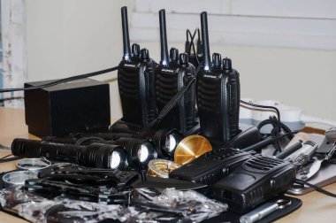 Occitanie, Fransa - Aralık 2021 - Bazı hayatta kalma ekipmanları polis kuvvetleri: şarj olan rıhtımlarında çok sayıda telsizi olan bir radyo istasyonu, metal ışıklı ışıklar ve yaldızlı çantalı bir pusula