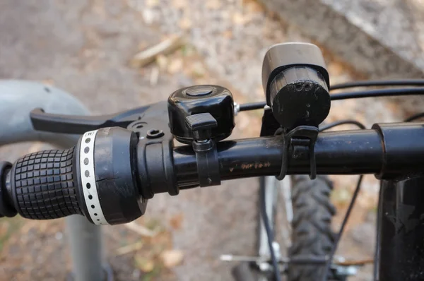 山地自行车黑色铝制手柄条的细部 可以更仔细地观察轮班杆 左制动器杆的扭力握力 并与电缆 小铃铛和前灯相连 — 图库照片