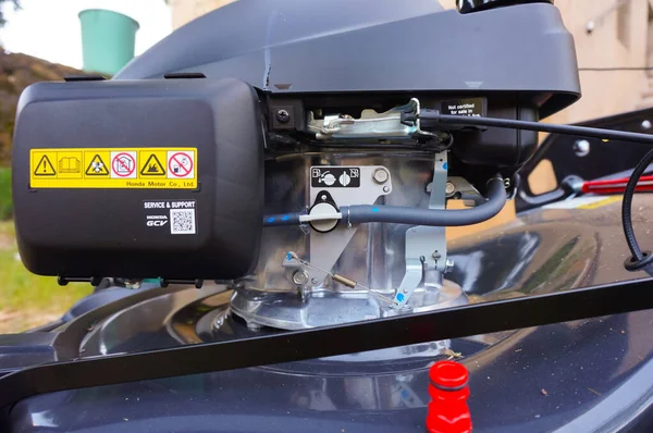 法国塔恩 2020年5月 日本汽车制造商本田 Honda 驱动的草坪割草机发动机组件详情 其进口软管上有燃料阀门 发动机上有节流阀和离合器电缆 — 图库照片