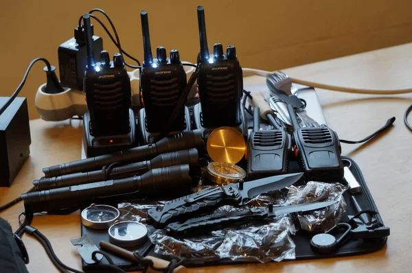 Occitanie, Fransa - Aralık 2021 - Bazı hayatta kalma ekipmanları polis kuvvetleri: şarj olan rıhtımlarında çok sayıda telsizi olan bir radyo istasyonu, metal ışıklı ışıklar ve yaldızlı çantalı bir pusula 