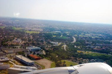 Fransa 'nın Toulouse kentindeki sanayi bölgelerinin, banliyölerin ve yolların ön planda ve hava manzarasında yükselen ve yükselen bir uçağın motoru, ufukta tarlalar ve kırsal manzarayla birlikte
