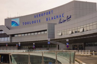 Toulouse, Fransa - Ekim 2020 - Toulouse-Blagnac Uluslararası Havalimanı 'nın ana binası, taksiler için yükseltilmiş cam bir kapı, iniş şeridi ve koyu pencereli beton cephe