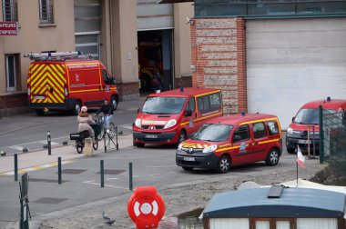 Toulouse, Fransa - Nisan 2023 - Le Busca bölgesindeki Canal du Midi Canal du Midi 'nin Saint-Sauveur Port İtfaiye İstasyonu' na park etmiş kırmızı acil durum araçları, iki minivan ve daha büyük bir minibüs