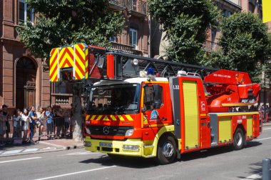Albi, Fransa - 14 Temmuz 2022 - Tarn itfaiyesinden kırmızı Mercedes-Benz kamyonu, modern bir teleskopik merdiven ile donatılmış, Ulusal Gün geçit törenine katılmak üzere hareket ediyor.