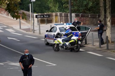 Albi, Fransa - Eylül 2021 - Polis memurları, yaya olarak, arabayla ve motosikletle barikatta, sağlık geçişi ve Covid ölçümlerine karşı düzenlenen gösteri sırasında sokaktaki trafiği kontrol ediyorlar.