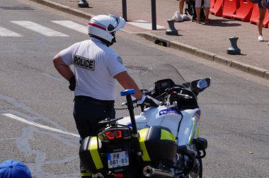 Albi, Fransa - Ağustos 2021 - Başlık takan, motosikletli bir Ulusal Polis memuru, sağlık izni ve Covid ölçümlerine karşı düzenlenen bir gösteri sırasında trafiği bir barikatta yönlendiriyor.