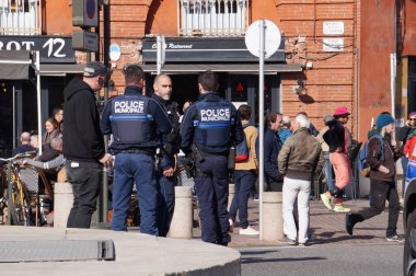 Toulouse, Fransa - Şubat 2023 - Saint-Cyprien Meydanı 'nda emekli aylığı reformunu protesto eden ve taktik yelek giyen üç silahlı polis memurundan oluşan bir grup