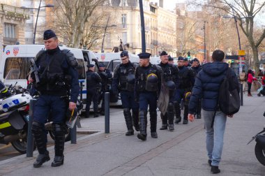Toulouse, Fransa. 2020 - Fransız SWAT subayları (CRS) ağır çelik yelek, miğfer ve el bombası fırlatıcılarıyla, bir polis operasyonunun sonunda bir gösteride minibüslere biniyorlar.
