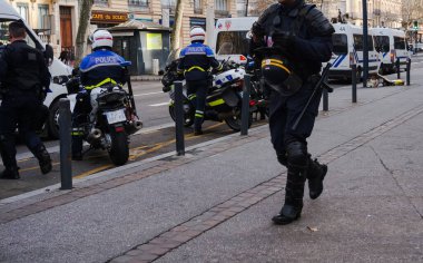Toulouse, Fransa. 2020 - Fransız SWAT subayları (CRS) ağır çelik yelek, miğfer ve el bombası fırlatıcılarıyla, bir polis operasyonunun sonunda bir gösteride minibüslere biniyorlar.