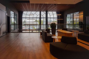 Saint-Julien-les-Villas, Fransa - Eylül 2020 - Marques Bulvarı 'ndaki fabrika merkezinin penceresinin önündeki ahşap zemin ve mobilyaları, kanepeleri ve kanepeleri olan müşteriler için bir karşılama salonu