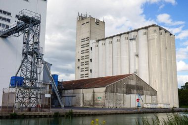 Reims, Fransa - Mayıs 2021 - Marne-Aisne Kanalı 'nın Pre des Moines rıhtımında güçlü bir tarım şirketine ev sahipliği yapan tahıl asansörleri ve sanayi fabrikaları